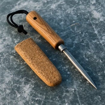 Spud bar and a plastic hole sleeve set beside a drilled ice hole